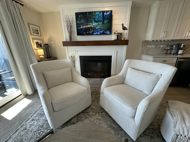 living area with a large fireplace and light wood-style flooring