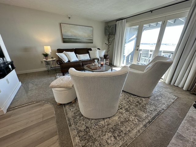 living area featuring a textured ceiling and baseboards