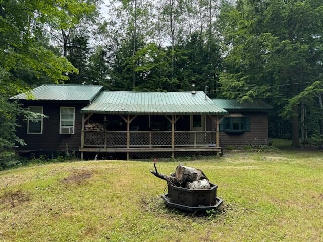 view of front of house featuring a fire pit, metal roof, and a front yard