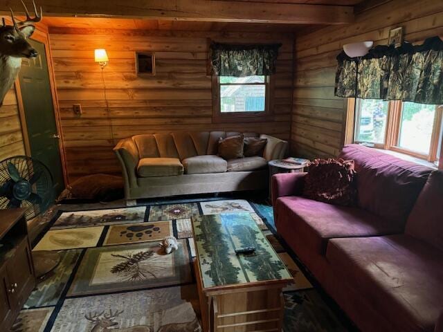 living area featuring beamed ceiling and log walls