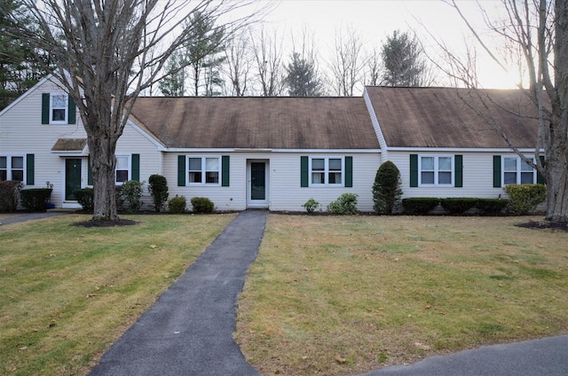 view of property with aphalt driveway and a front yard