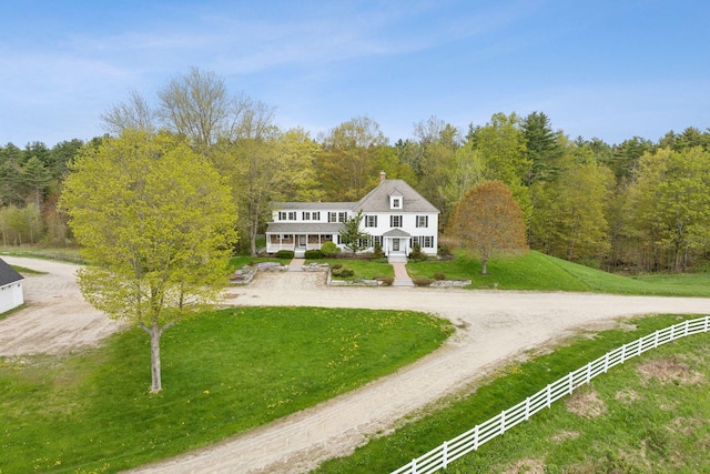 49 Megquier Rd, Gray, ME 04039 - view of front of property with a view of trees, a front lawn, curved driveway, a porch, and a chimney