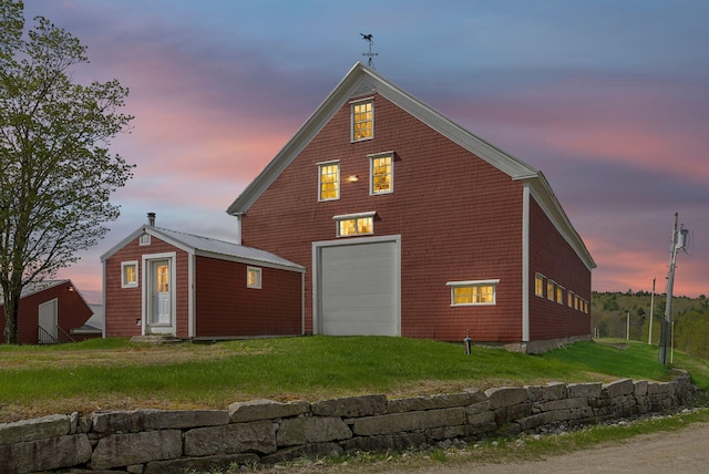 49 Megquier Rd, Gray, ME 04039 - back of house at dusk with a lawn and a detached garage