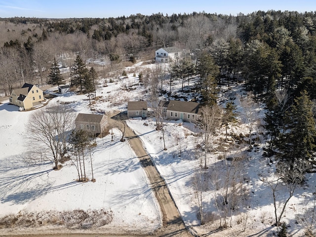 snowy aerial view with a wooded view