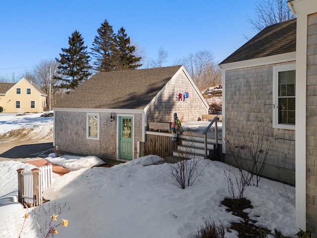 view of snowy exterior featuring a shingled roof