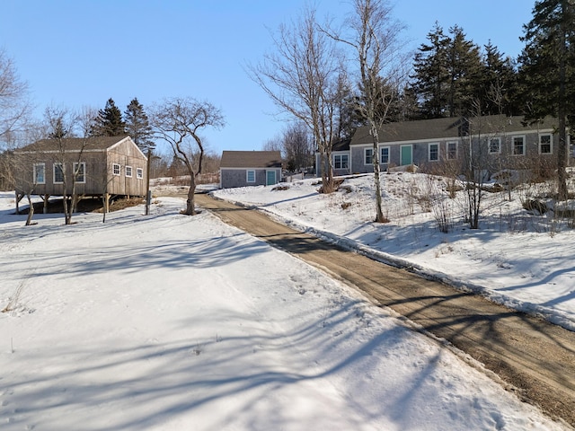 yard layered in snow featuring an outbuilding