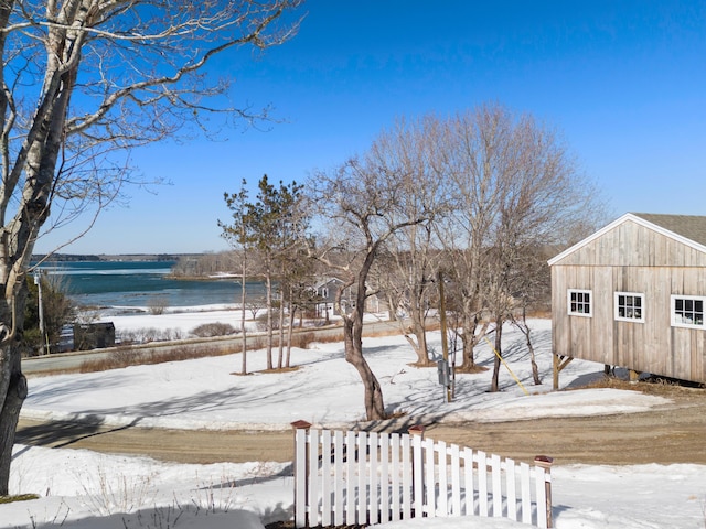 yard covered in snow with a water view