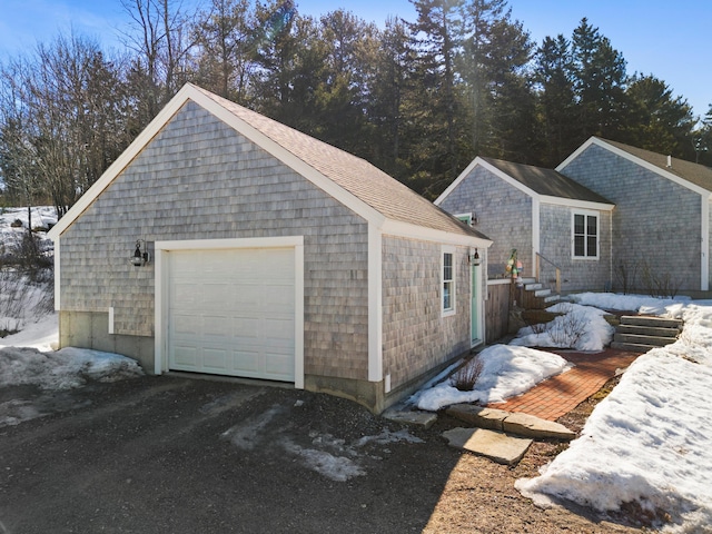 snow covered garage featuring a detached garage