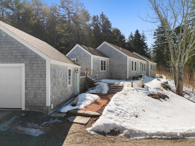 view of snow covered exterior with a garage