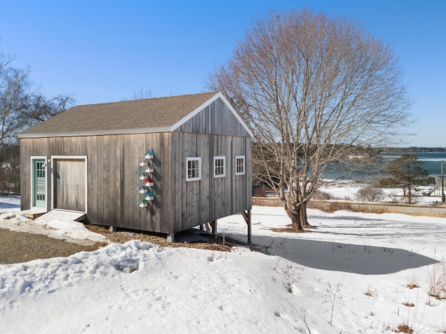 snow covered structure featuring an outbuilding