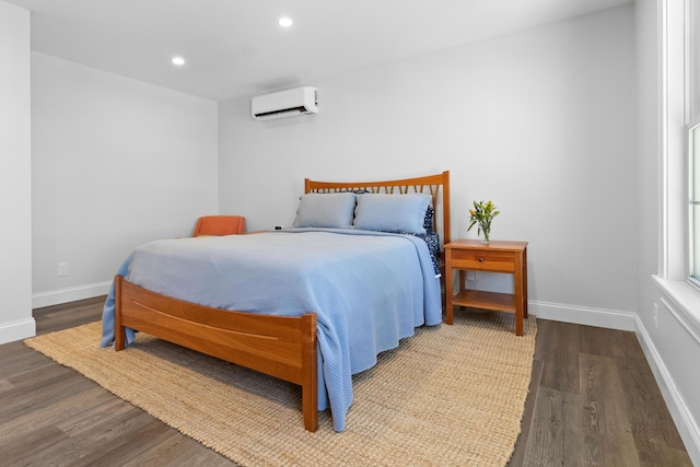 bedroom with recessed lighting, baseboards, wood finished floors, and a wall mounted air conditioner