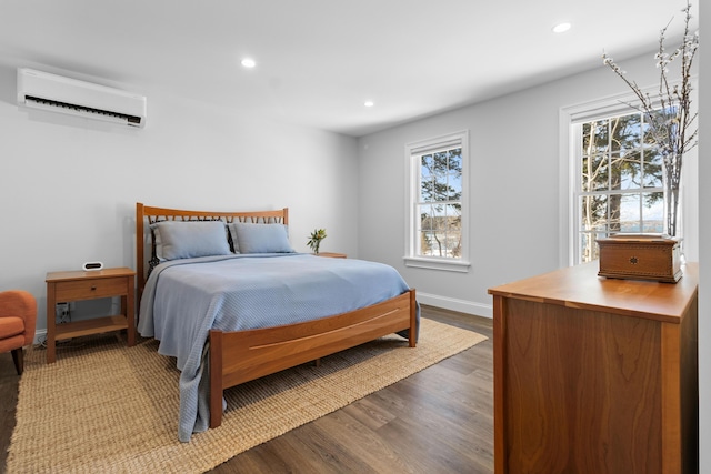 bedroom featuring recessed lighting, wood finished floors, multiple windows, and a wall mounted AC