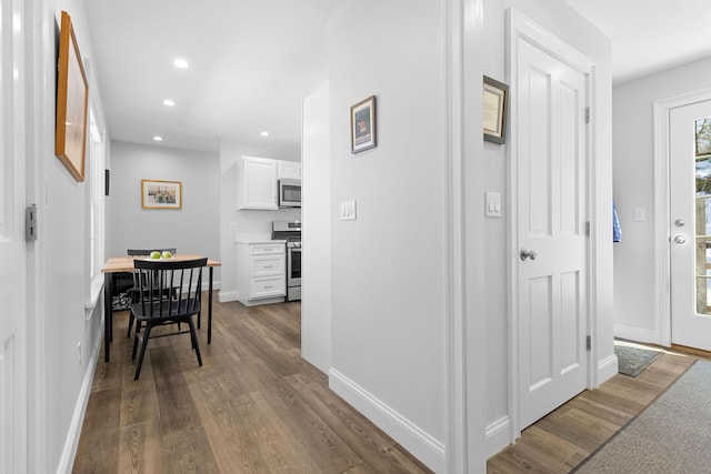 hallway with baseboards, dark wood finished floors, and recessed lighting