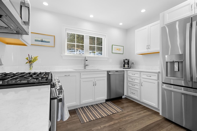 kitchen with stainless steel appliances, dark wood finished floors, white cabinets, and a sink