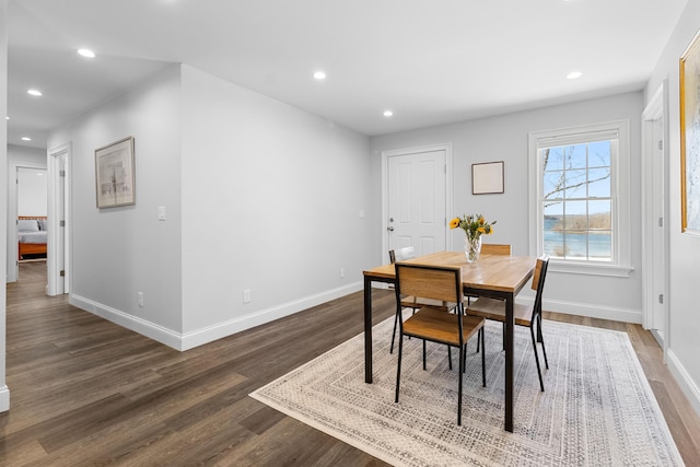 dining room featuring baseboards, wood finished floors, and recessed lighting