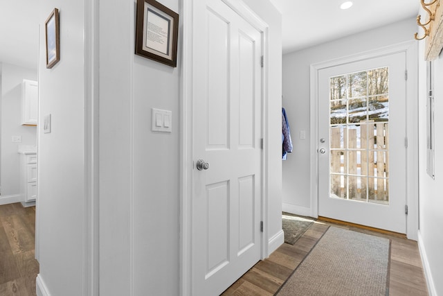 doorway featuring a wealth of natural light, baseboards, and wood finished floors