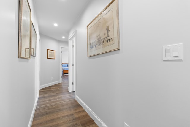 hall featuring dark wood-style floors, recessed lighting, and baseboards