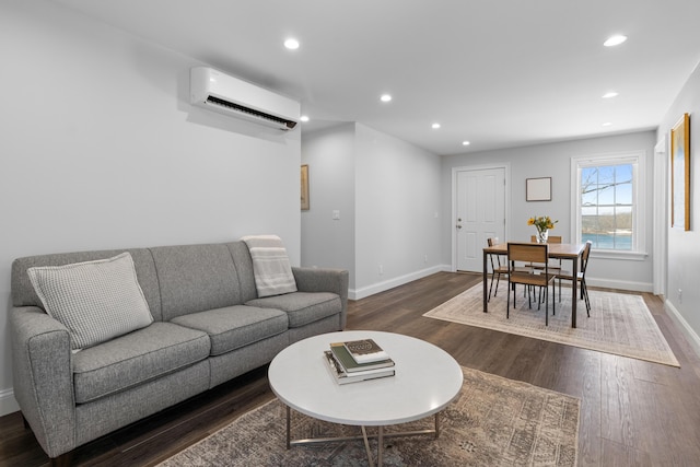 living area with recessed lighting, a wall mounted air conditioner, dark wood finished floors, and baseboards