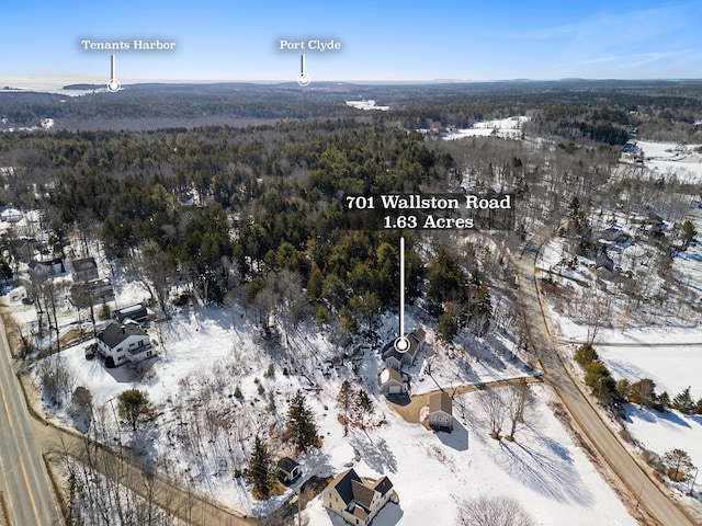 snowy aerial view featuring a forest view