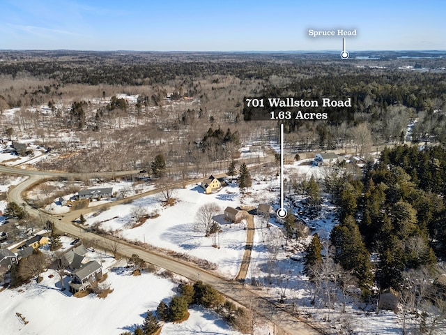 snowy aerial view with a wooded view