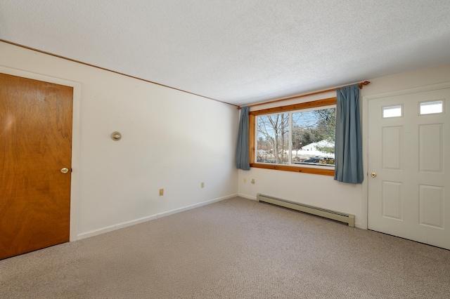 interior space with carpet, baseboards, a textured ceiling, and baseboard heating