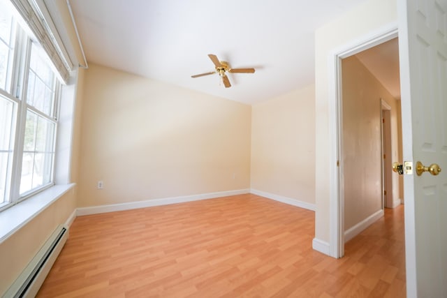 spare room with baseboards, light wood finished floors, and baseboard heating