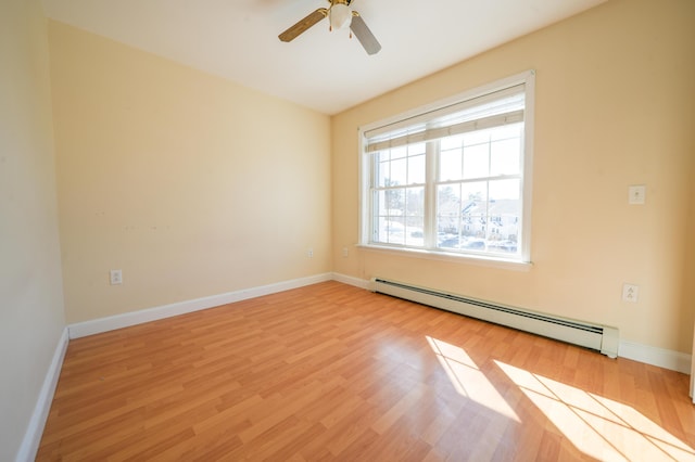 spare room with ceiling fan, light wood-type flooring, a baseboard radiator, and baseboards