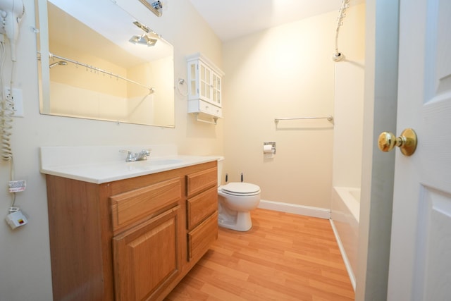 full bath with vanity, wood finished floors, toilet, and baseboards