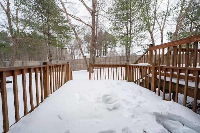 snow covered deck featuring a fenced backyard