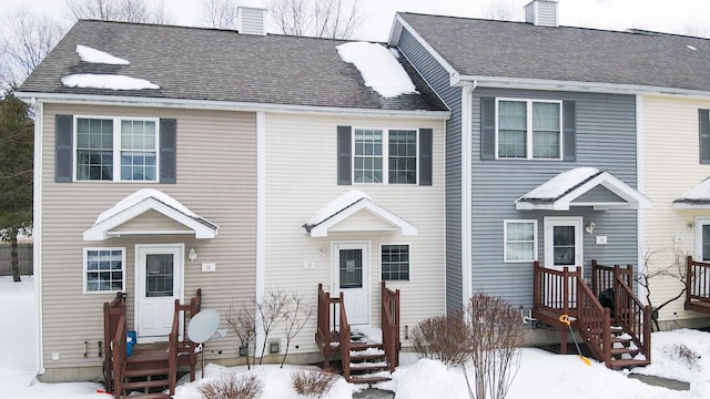 view of front of house with a shingled roof and a chimney