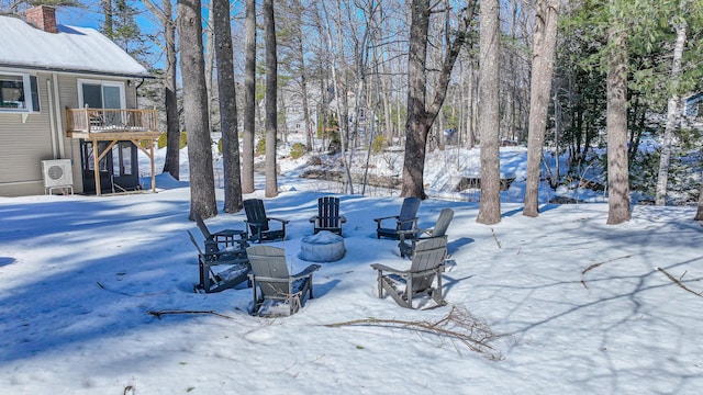 yard covered in snow featuring an outdoor fire pit and a deck