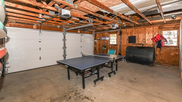 garage featuring heating fuel, wooden walls, and a garage door opener