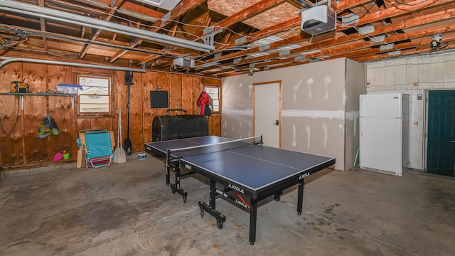 rec room featuring a garage, heating fuel, and concrete flooring