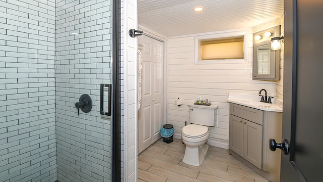 bathroom with a stall shower, wood finish floors, vanity, and toilet