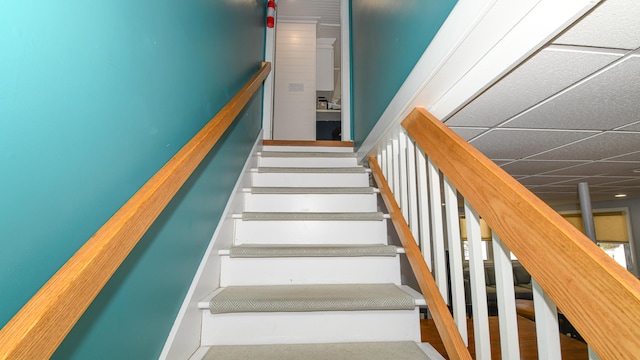 stairway with a paneled ceiling