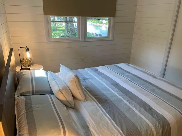 bedroom featuring wooden walls