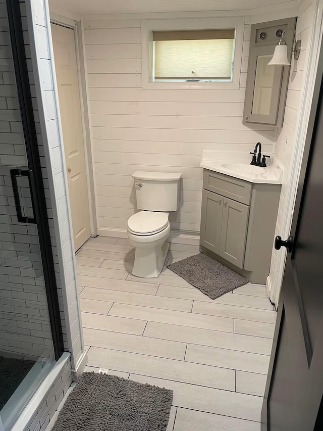 full bathroom featuring toilet, wood finished floors, a shower stall, and vanity