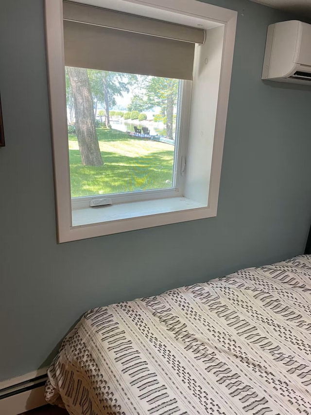 bedroom featuring a baseboard heating unit and a wall unit AC