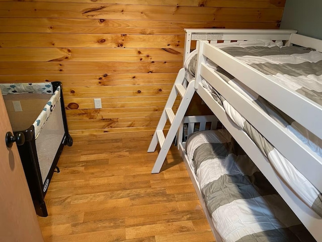 bedroom with wood walls, light wood-style flooring, and a sauna