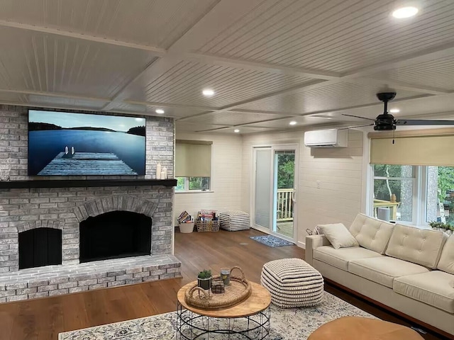 living room with wood ceiling, an AC wall unit, wood finished floors, and a wealth of natural light