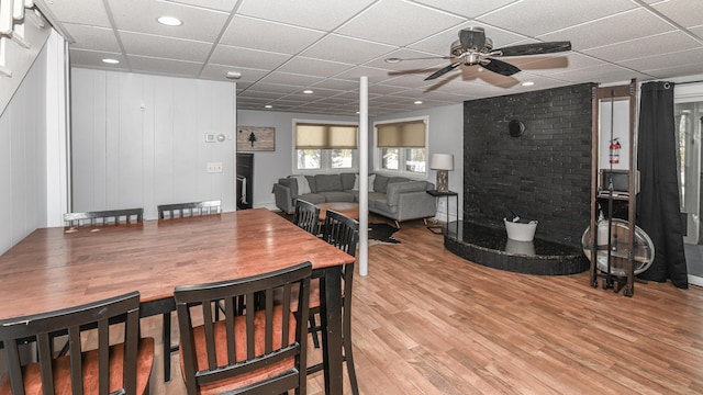 dining space with a ceiling fan, light wood-type flooring, and a paneled ceiling