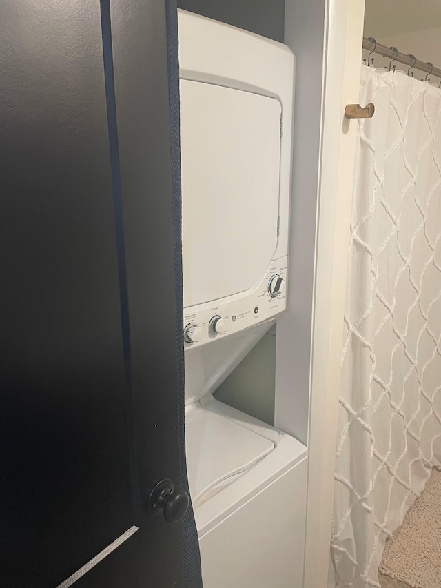 clothes washing area featuring laundry area and stacked washing maching and dryer