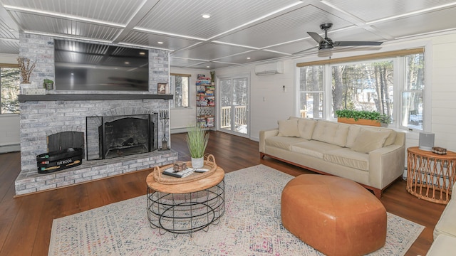 living room with an AC wall unit, coffered ceiling, wood finished floors, and a brick fireplace