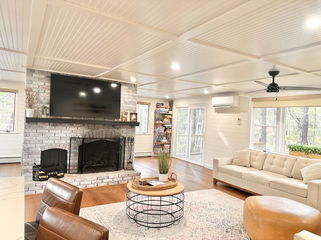 7 Birch Dr, Raymond, ME 04071 - living area featuring a wall mounted AC, a fireplace, a ceiling fan, wood finished floors, and a baseboard radiator