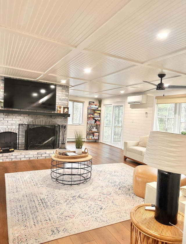 7 Birch Dr, Raymond, ME 04071 - living area featuring wood-type flooring, a ceiling fan, a wall mounted AC, and a fireplace