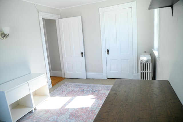 unfurnished bedroom featuring radiator and baseboards