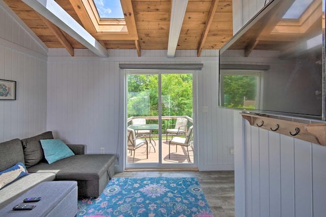 living room with vaulted ceiling with skylight, wood ceiling, and wood finished floors