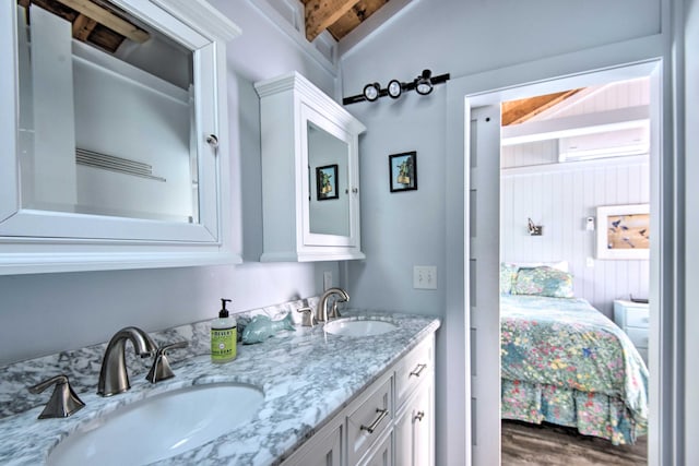 ensuite bathroom with double vanity, wood finished floors, ensuite bath, and a sink