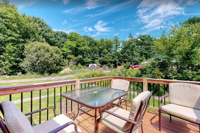 wooden deck with outdoor dining area and a yard