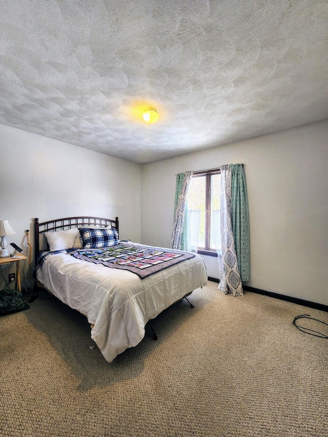 bedroom featuring carpet flooring, a textured ceiling, and baseboards